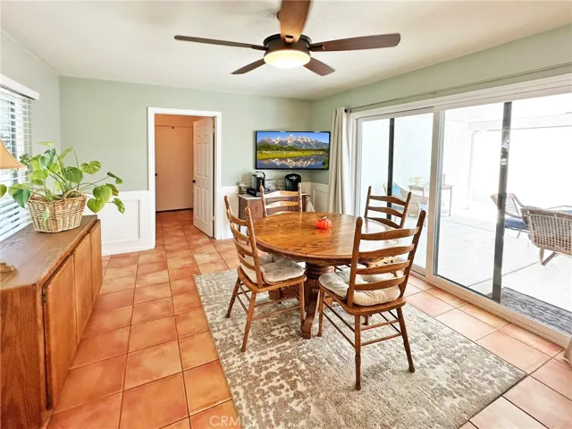 Kitchen dining area has been beautifully upgraded with wainscoting, raised panel door to indoor laundry room, dual pane sliding door that leads to outdoor covered entertaining area, dual paned window, and ceiling fan.