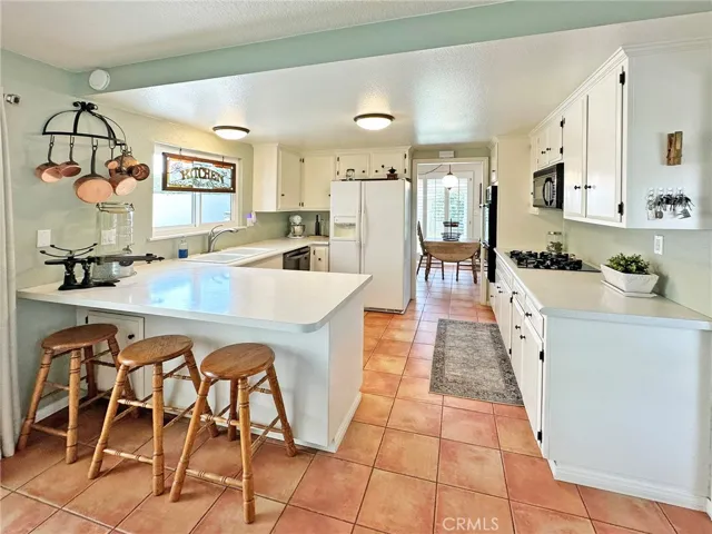 Light and bright kitchen with breakfast bar, lots of storage, gas stove, wall oven, microwave and stainless-steel dishwasher