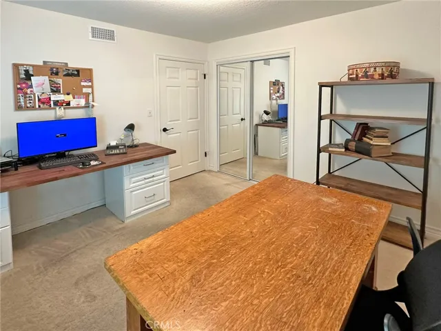Fourth bedroom has mirrored closet doors and is currently used as home office.