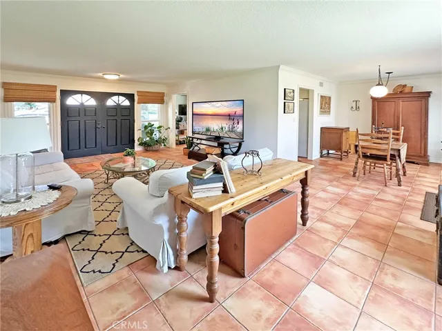 Livingroom and adjacent dining room have crown moulding, dual pane windows with custom window and door casements, and custom window treatments.