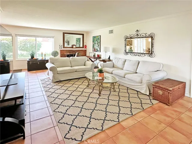 Large Livingroom with brick fireplace, crown moulding, and lots of natural light through dual pane windows.