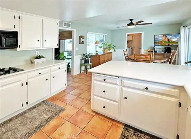 Kitchen with breakfast bar is light and bright, opens to large kitchen dining area with wainscoting, dual pane window and sliding door to large covered outdoor entertaining area.
