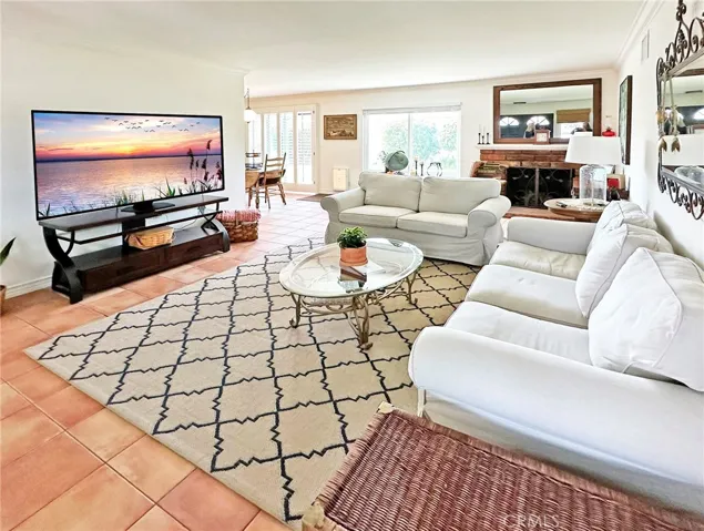 Livingroom with brick fireplace opens to spacious formal dining area with dual pane back slider and custom plantation shutters.