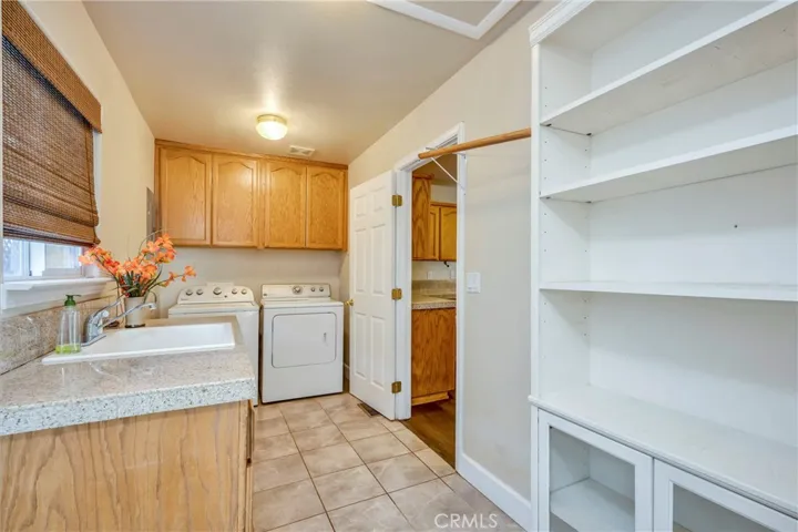 Laundry/ utility room off kitchen has extra storage to serve as pantry, plus a utility sink.