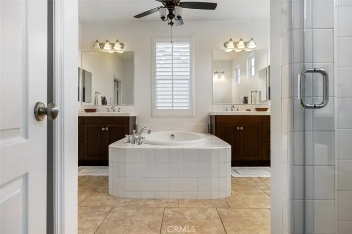 Primary bathroom with two vanities and soaking tub along with a freestanding shower.
