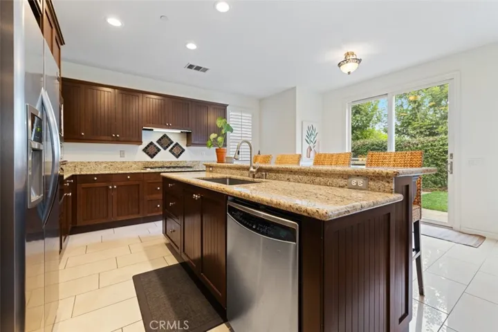 Chef's kitchen with tile floors, granite counters and stainless steel appliances.