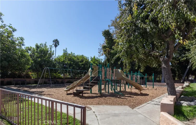 Community playground behind the property with equipment, swings and sitting areas.