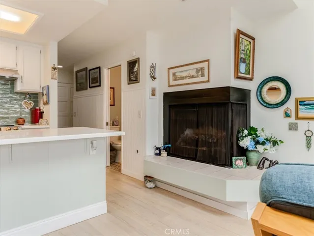 Photo of fireplace, kitchen and half bath.
