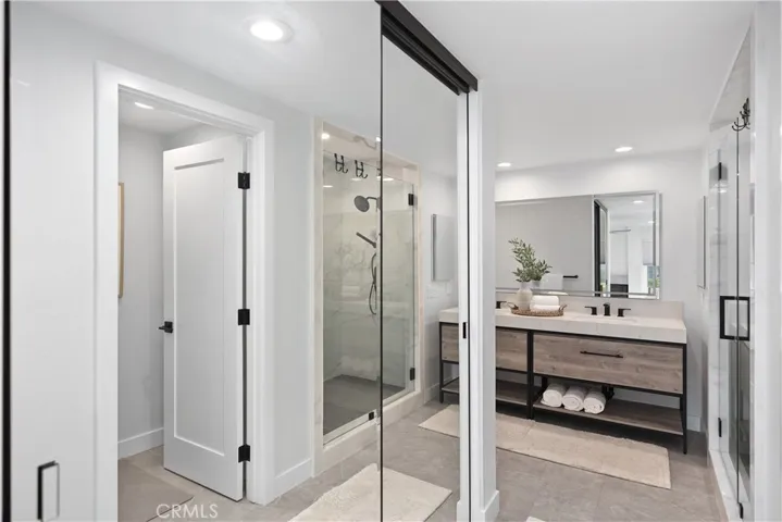 Large walk-in closet with mirrored closet doors.