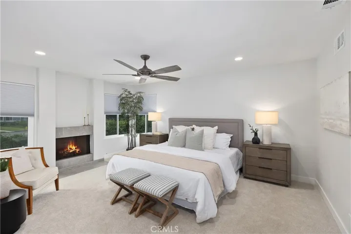 Primary en-suite that features fireplace, recessed lighting and ceiling fan.