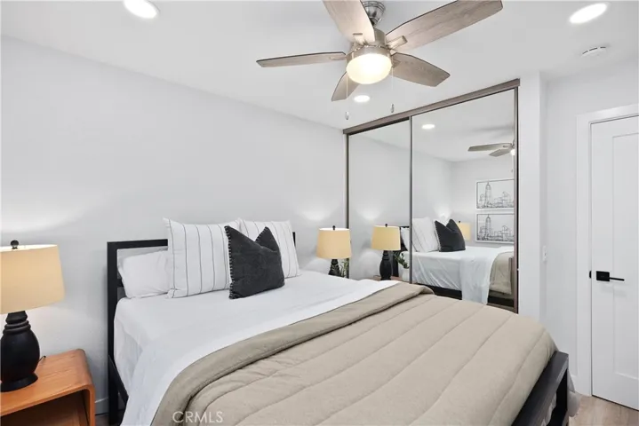 This secondary bedroom features ceiling fan, recessed light, and mirrored closet doors.