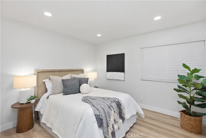 Downstairs bedroom with recessed lighting and mirrored closet doors.