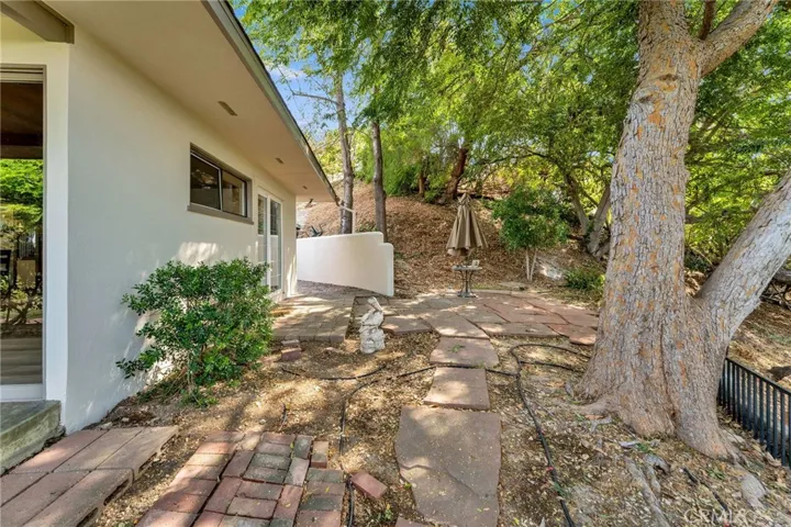 Walkway to the back of the home. There are a couple of more patios for dining and relaxing.