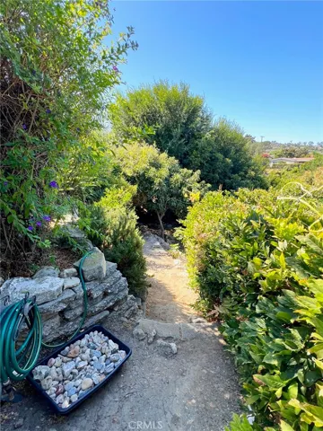 Inviting stone-lined walking path draws you  down to multiple flat pads for entertaining and play.
