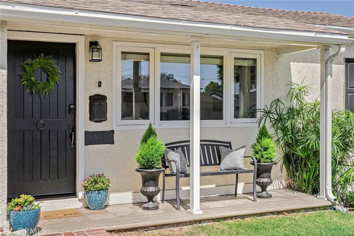 Covered front porch adds to curb appeal of white-picket-fenced front  yard.