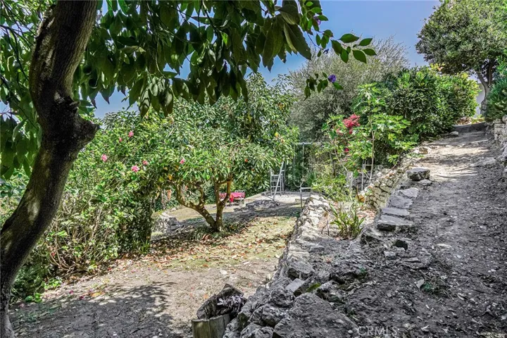 Inviting stone-lined walking path draws you down to multiple flat pads for entertaining and play.