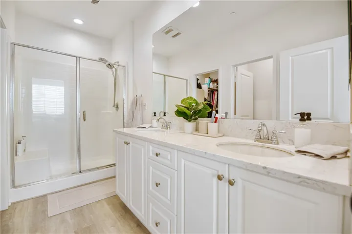 Primary bathroom features double sinks, beautiful Formica countertops, a large walk-in shower, and privacy toilet area.