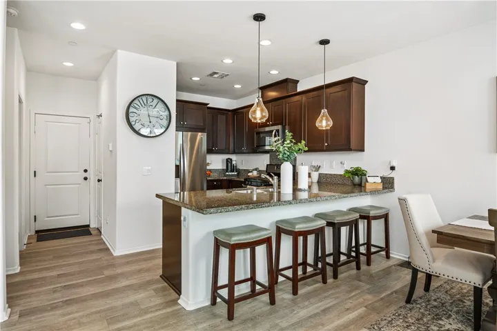 Kitchen features granite countertops, upgraded maple cabinets, and Whirlpool stainless steel appliances. Refrigerator is included.