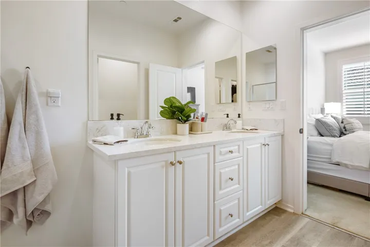 Primary bathroom features double sinks, beautiful Formica countertops, a large walk-in shower, and privacy toilet area.
