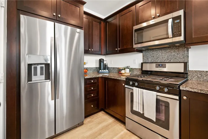 Kitchen features granite countertops, upgraded maple cabinets, and Whirlpool stainless steel appliances.