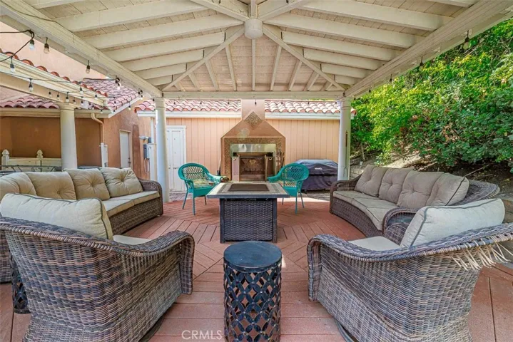View towards the fireplace and underneath the cover of the outdoor living space.