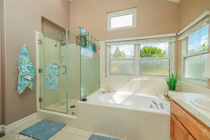 View of the deep soaking tub and separate stall shower. The bath suite is filled with natural light and also has vaulted ceiling, adding to the spacious feel