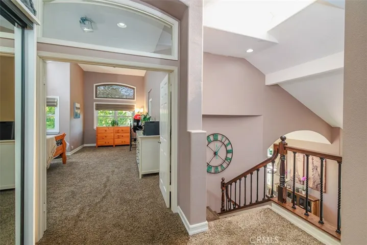 Coming upstairs to the hall outside the bedrooms. View is through the double-door entrance into the primary bedroom