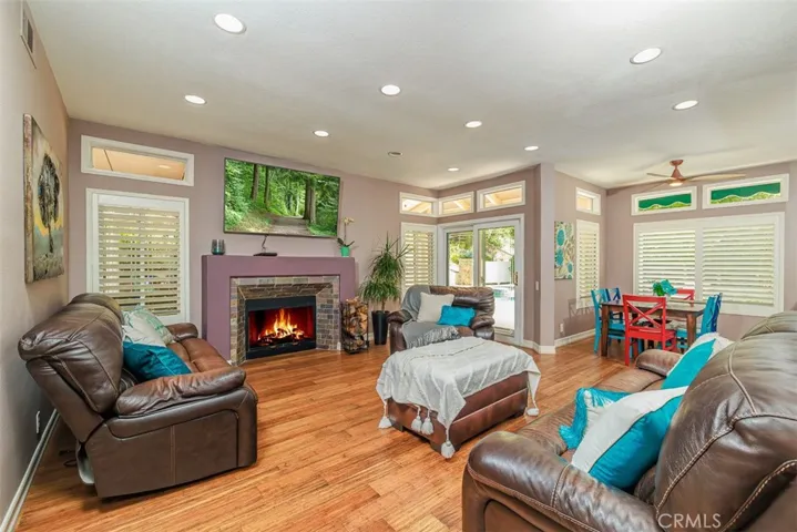 Stepping into the family room featuring a fireplace and added recessed lighting. There's a sliding door to the back patio.