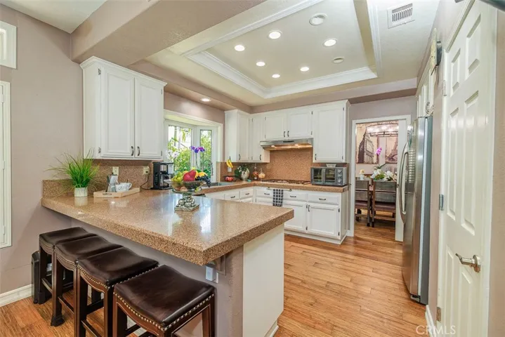 The sunny kitchen is open to the family room. Quartz-like counters, added recessed lighting, and a walk-in pantry are just some of the features