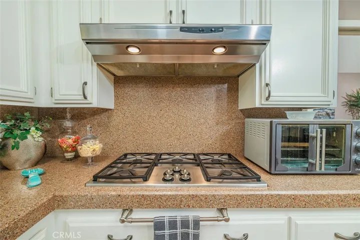 Five burner stainless gas cook top and stainless vent hood