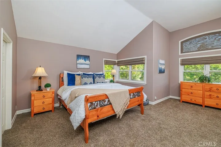 Primary bedroom has vaulted ceilings, an area for a retreat, designer paint, and en-suite bath suite