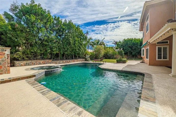 Stepping into the very private back yard, you'll find this beautiful pebble finish pool and spa, and plenty of lawn for entertaining
