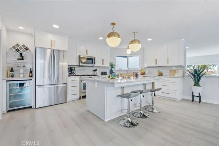 Huge quartz counter island with seating and cabinets and drawers by Mastercraft.