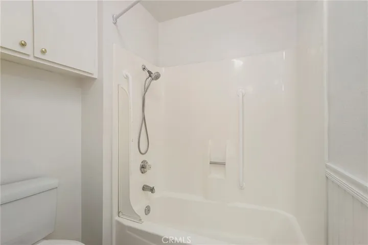 Primary Bathroom with toilet, tub/shower and storage