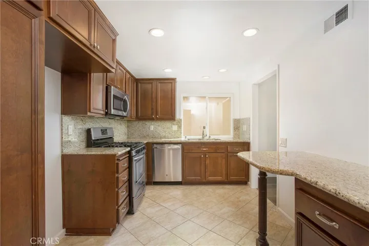 Kitchen with newer cabinets, Gas Stove, Granite Counters, Tile Flooring, Recessed Lighting, Window with over looking side patio area