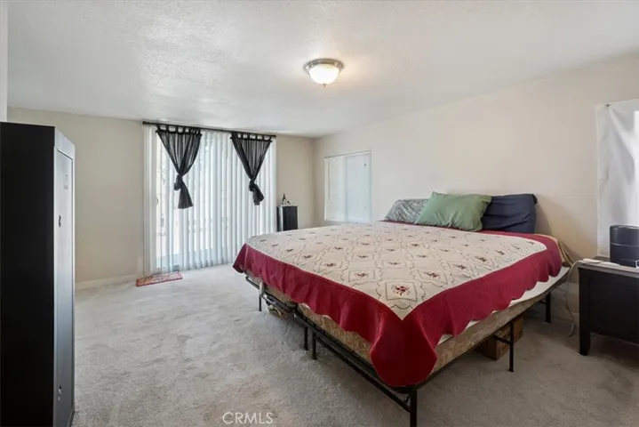 The large primary bedroom is in the back of the home and has a sliding glass door that goes to the balcony.
