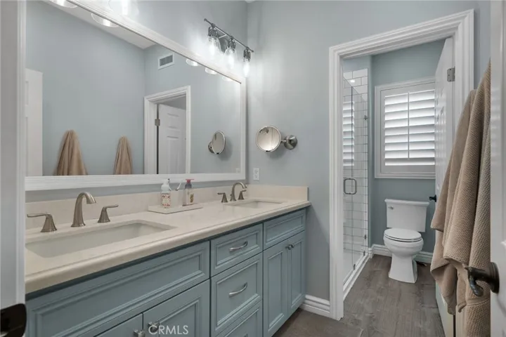 Upstairs bathroom with separate shower area boasts beautiful custom vanities with pull-outs for organization