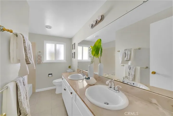 The guest bathroom features dual sinks and a tub/shower combo