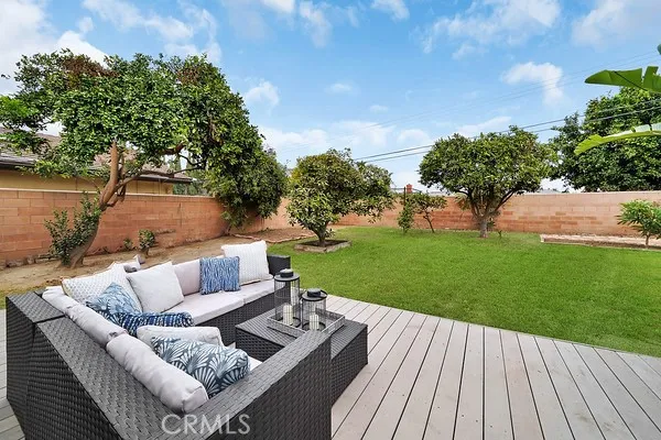 The expansive backyard is perfect for outdoor living, offering a raised entertainment deck, fruit trees, and a large grassy area ideal for play.