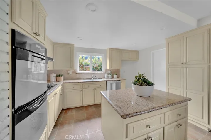 The upgraded kitchen features custom cabinetry, granite countertops, a high tiled backsplash, and top-of-the-line appliances. It boasts a Thermador 4-burner gas cooktop, Jenn-Air dual ovens, and a stainless steel KitchenAid dishwasher.
