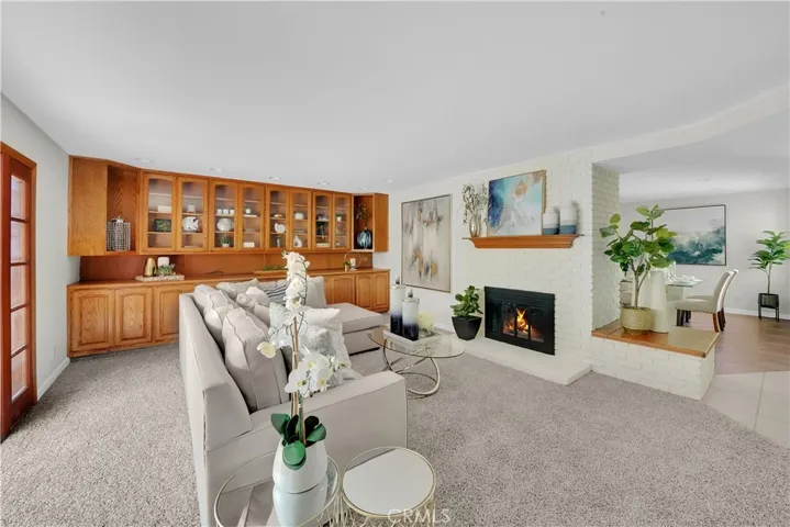 Relax in the generously sized living room, complete with a cozy white brick fireplace with glass doors and a wood mantel.