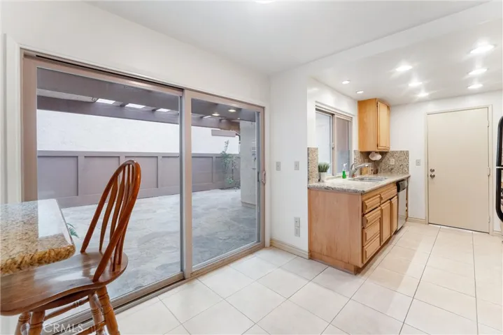 As you enter the large kitchen area you are greeted by the breakfast counter, sliding door that leads to the large front yard, granite kitchen counter tops.