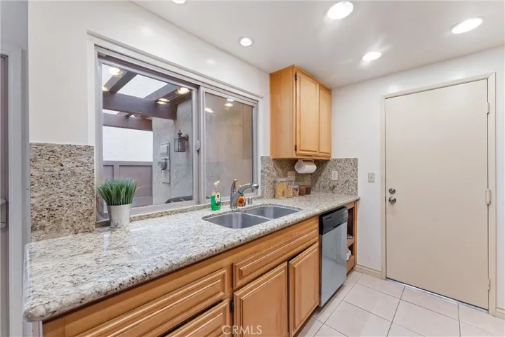 This angel you see the kitchen, countertop, sink, dishwasher, cabinets, and door that leads to two car attached garage and where the washer and dryer are located.