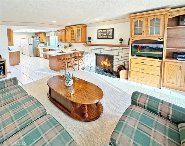 Family Room with Custom Built-In Entertainment System with Shelving and Cabinetry, Plus Fireplace and is Open to the Sunlit Kitchen