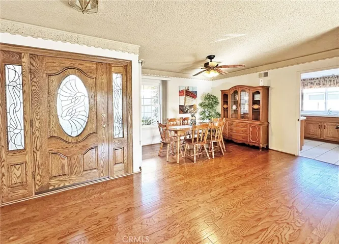 Solid Wood & Beveled Glass Entry Door with Matching Sidelights Opens to Engineered Hardwood Foyer
