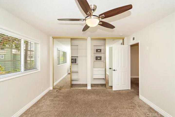 Built-in organizer and mirror closet doors at bedroom 2