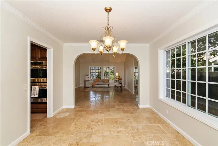 The living room effortlessly flows into formal dining through open arch walls, creating an expansive and connected living space, allowing natural light to travel freely between the 2 areas.