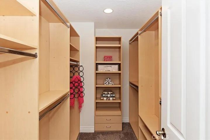 Fully customized walk-in closet with built-in organizer at Primary bedroom