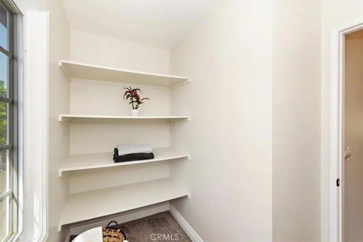 A bonus linen/utility storage room with built-in shelves and ironing board adds to the home's functional charm.