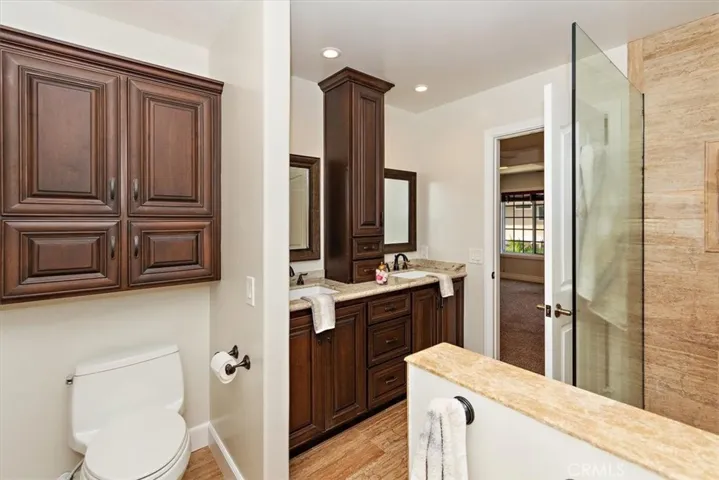 Granite countertops at dual sinks and abundant cohesive customized cabinetry